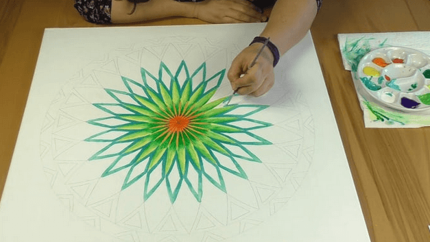 Energiebilder selber malen – Online Videomalkurs Mandala 28 Mandala mit grünem Blätterkranz und orangem Mittelpunkt wird vollendet