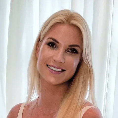 Porträt von Beate Rothmund, blonde Frau mit Lächeln vor weißem Hintergrund