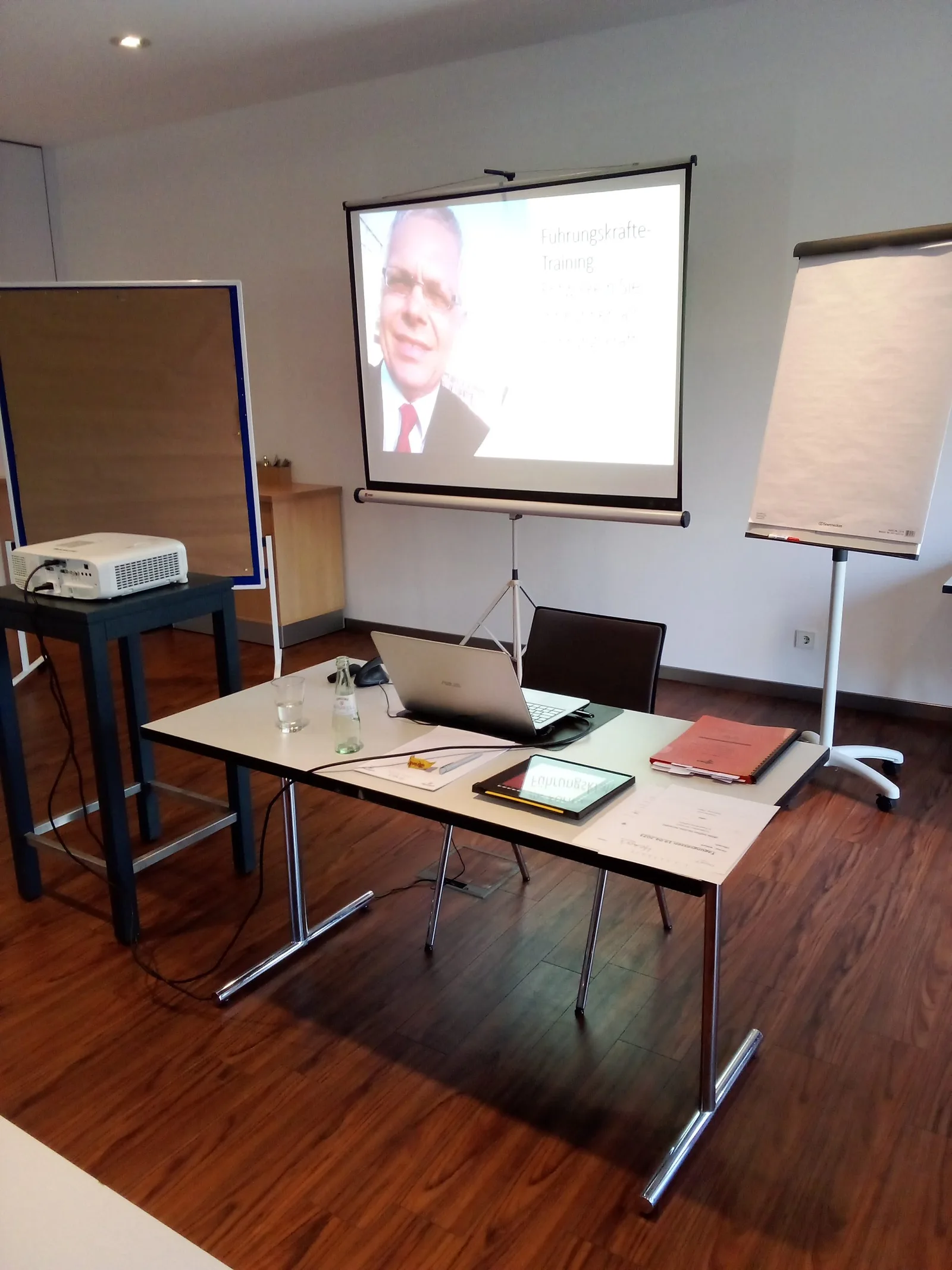 Trainingsraum mit Laptop, Beamer, Flipchart und Projektionsleinwand
