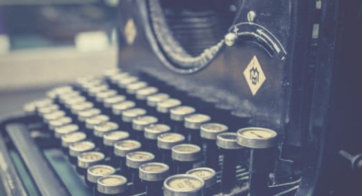 Vintage Schreibmaschine mit Papier und Kabel, Nahaufnahme der Tasten in Sepia-Tönen