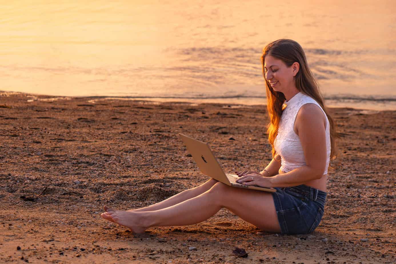 Escape the Office – Videokurs zum Online-Business von Barbara Riedel 12 Barbara Riedel sitzt am Strand mit MacBook auf Koh Phangan, Sonnenuntergang