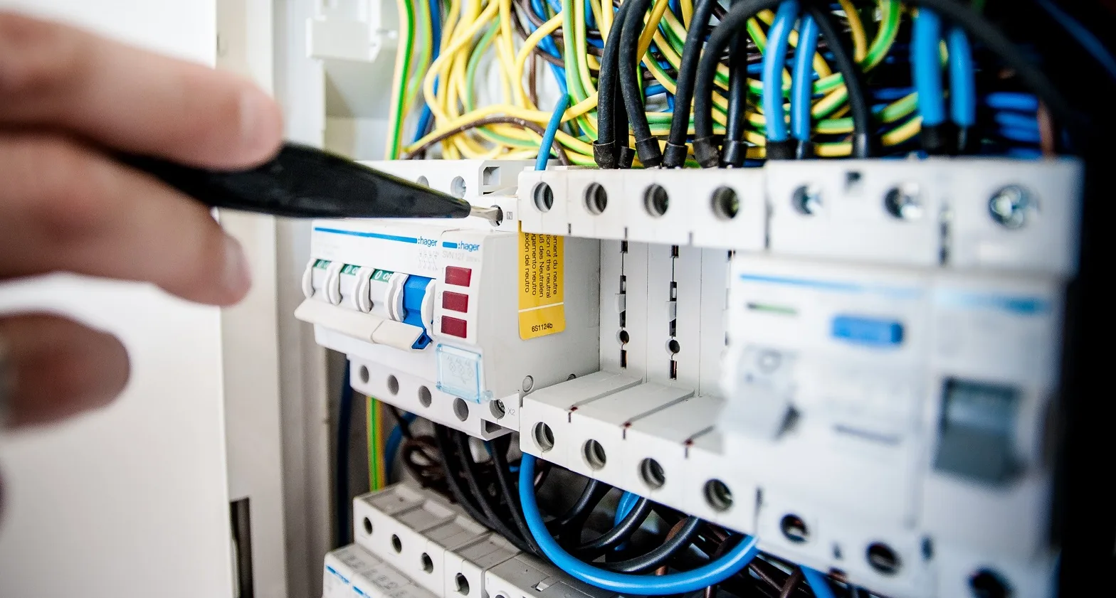 Elektrischer Schaltkasten mit Sicherungsschaltern und farbigen Kabeln in einer Installationstafel
