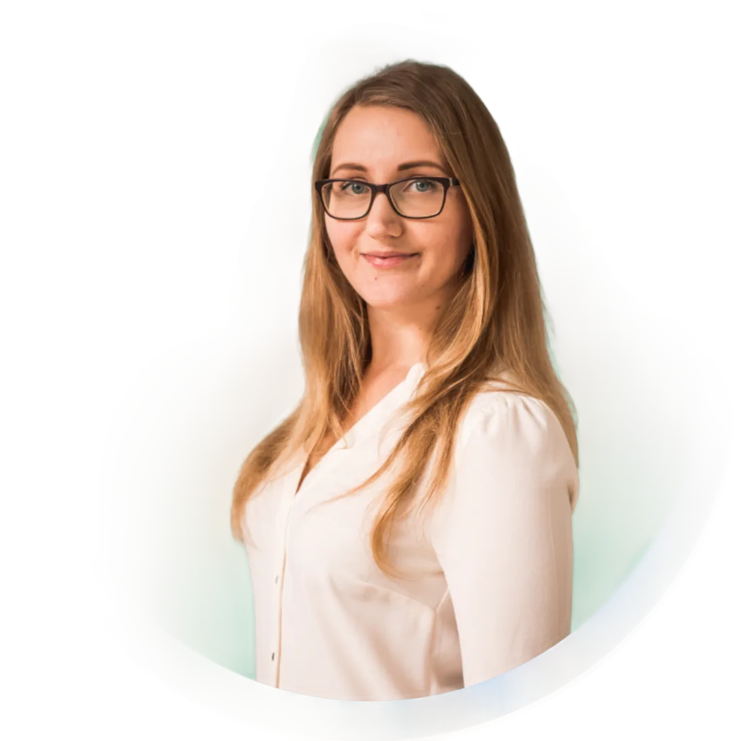 Profilbild Frau mit Brille und braunen Haaren in weißem Hemd vor hellem Hintergrund
