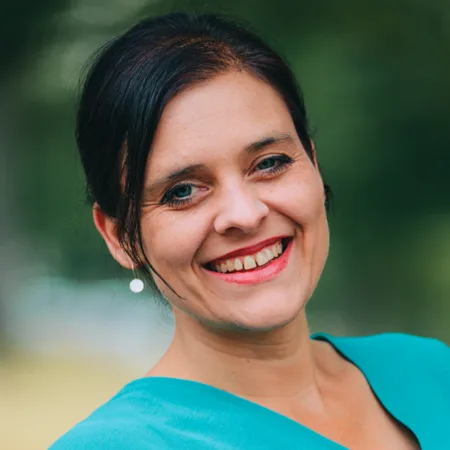 Expedition Familie – Videokurs für werdende Eltern 5 Porträt von Kelly Malottke mit grünem Hintergrund und rotem Lippenstift