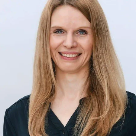 Expedition Familie – Videokurs für werdende Eltern 27 Porträt von Anne Henle mit braunem Haar und schwarzer Bluse vor weißem Hintergrund