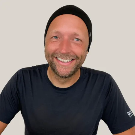 Expedition Familie – Videokurs für werdende Eltern 7 Porträt von Markus Asano mit schwarzem Beanie und schwarzem T-Shirt