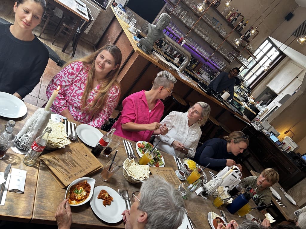 Gruppe von Frauen beim Dinner an gedecktem Holztisch – Netzwerkevent Frau mit Bizz