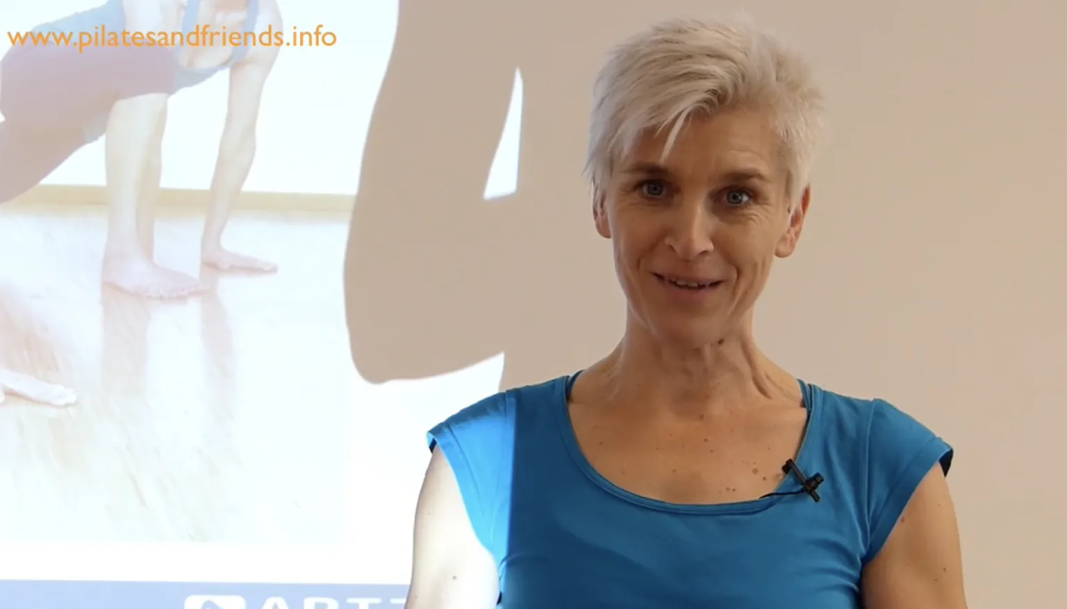 Trainerin in blauem Top vor Ballettstudio mit Spitzenschuhen, Workshop Fascial Dance