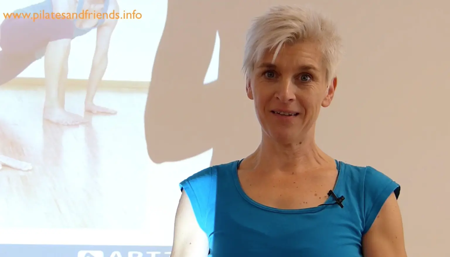 Trainerin in blauem Top vor Ballettstudio mit Spitzenschuhen, Workshop Fascial Dance