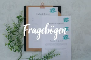 Fragebögen auf Holz-Klemmbrett mit Schriftzug und Broschüren auf Betonuntergrund