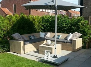 Moderne Gartenmöbel aus Holz mit Sonnenschirm auf grüner Rasenfläche