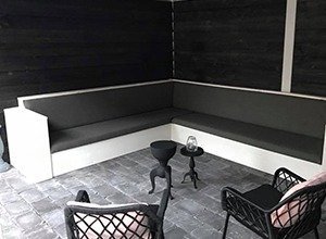 Moderne schwarze Lounge-Sitzecke mit weißen Akzenten auf Terrassenboden