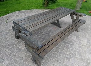 Massive Holzpicknick-Bank mit integriertem Tisch auf Pflastersteinen