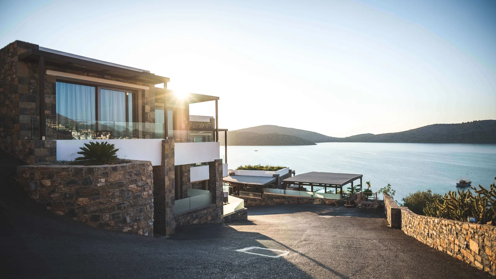 Modernes Steinhaus mit Veranda und Meerblick bei Sonnenaufgang, luxuriöse Immobilie