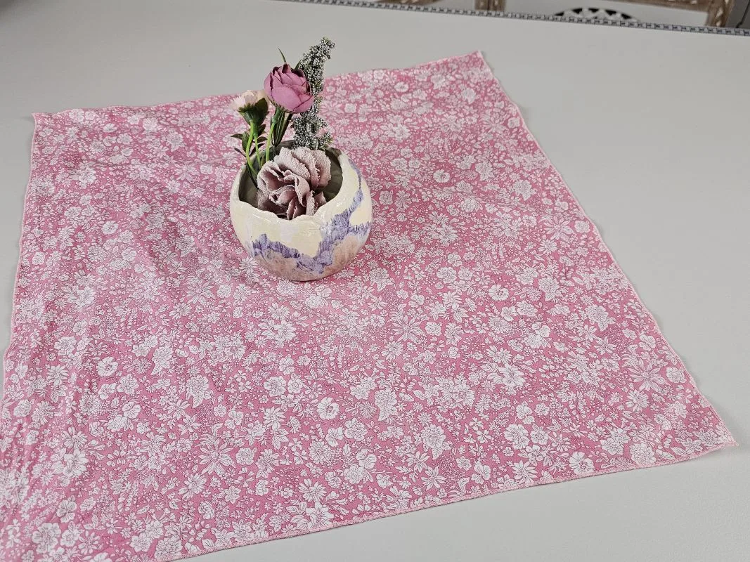 Rosa Furoshiki-Mitteldecke mit Blumenmuster und Blumenarrangement