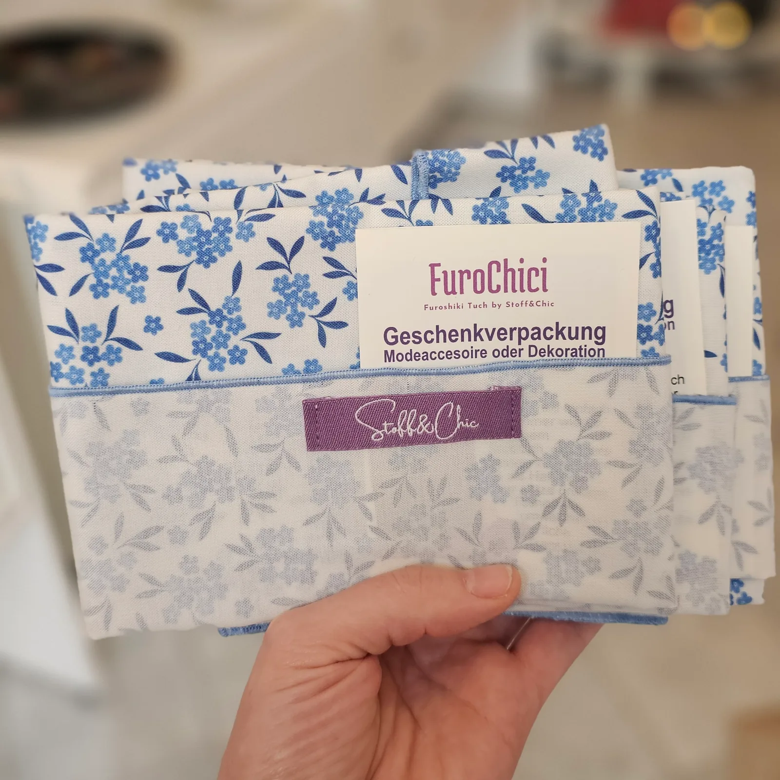 FuroChici Furoshiki-Tuch mit Etikett in Hand, blau-weiß Blumenmuster