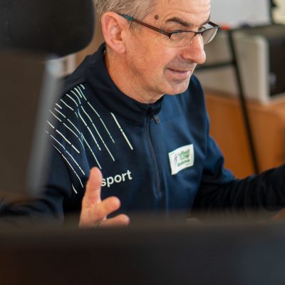 Fußball FLOW Akademie – Mentalcoaching für Kicker 4 Trainer mit Brille in blauer Uhlsport-Kleidung mit Akademie-Badge