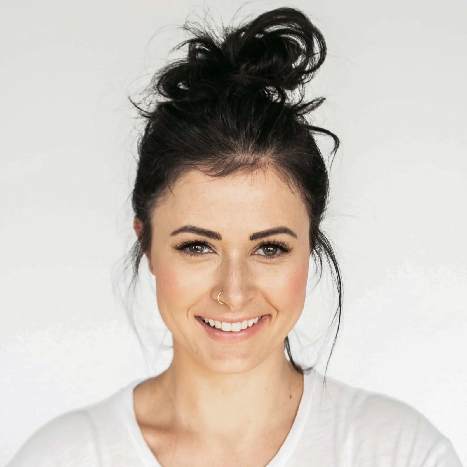 Porträtfoto von Felicitas Hestermann mit schwarzem Dutt-Haar und Lächeln