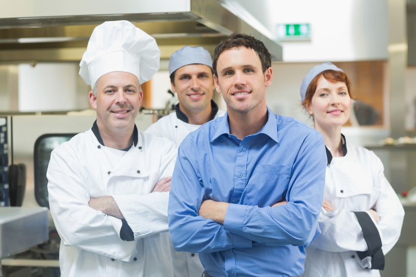 Gastronom und sein Team von drei Mitarbeitern in professioneller Küche
