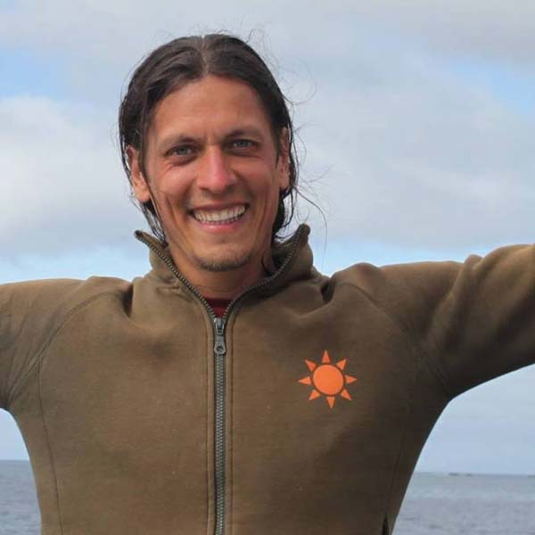 Leander Portrait mit Sonne-Logo auf Jacke am Meer, Portrait