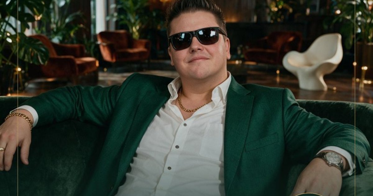 Mann in grünem Blazer und Sonnenbrille sitzt entspannt in modernem Lounge-Interior