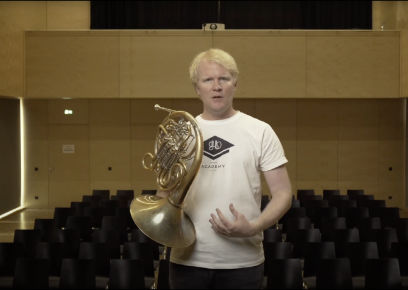 Hornist mit goldenem Instrument im Kinosaal während Masterclass