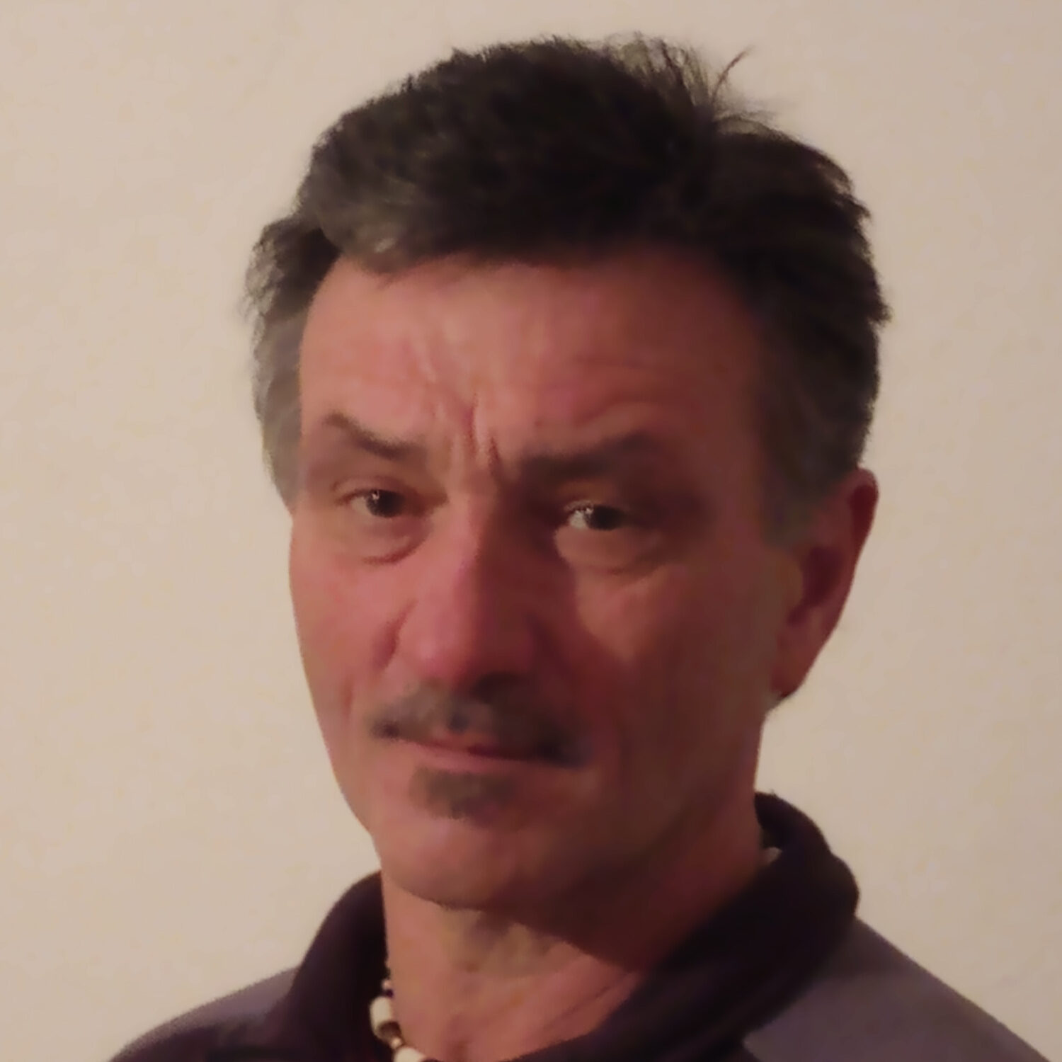 Franz Kapser in schwarzem Hemd vor hellgrauem Hintergrund