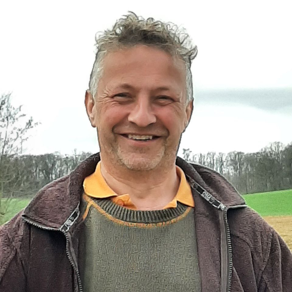 Carl Beier Forstwirt in Jacke und Hemd vor grünem Waldrand