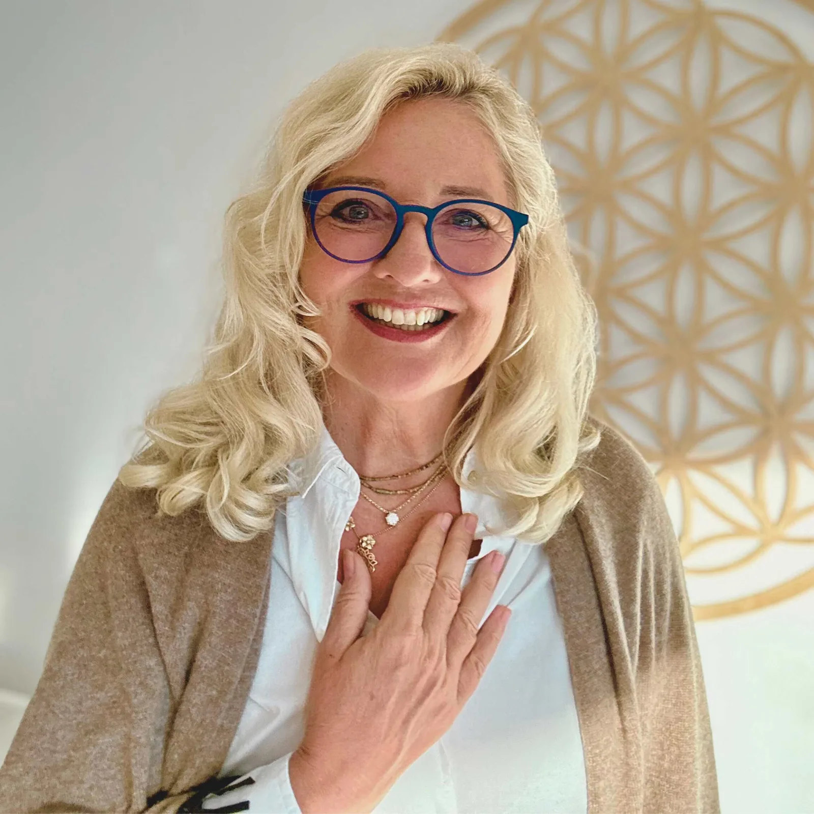 Porträt von Ina Elnain, Frau mit blonder Welle, Brille und beiger Strickjacke