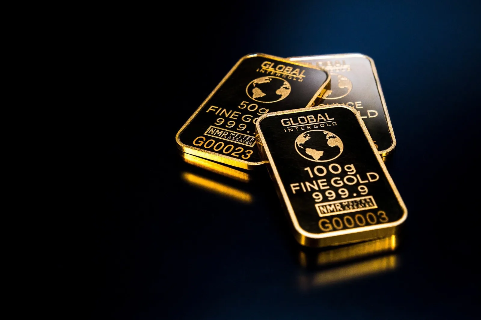 Zwei Goldbarren der Marke Global Intergold mit Feinheit 999.9 auf dunklem Hintergrund
