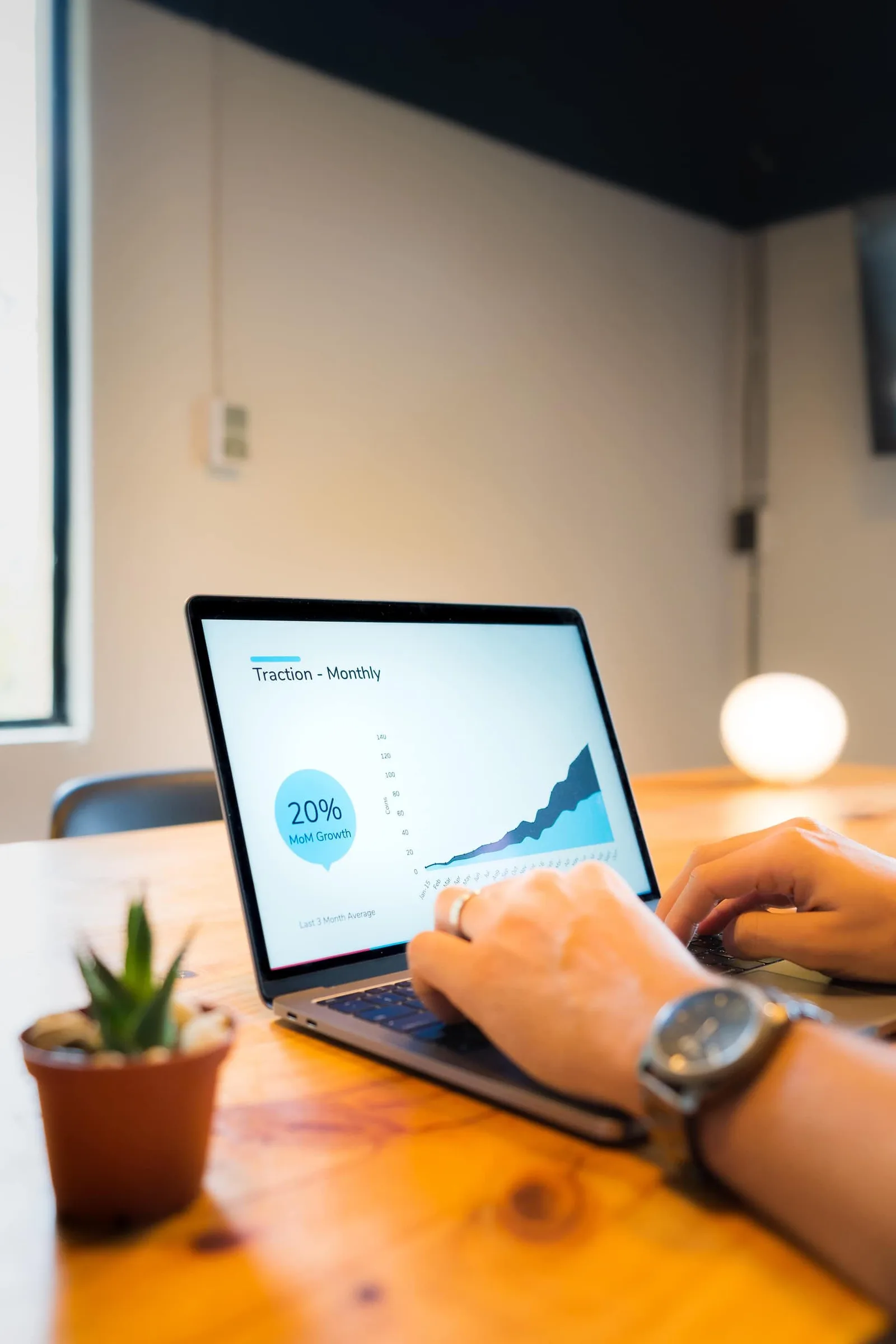 Person arbeitet am Laptop mit Traction-Grafik und 20% MoM Growth Daten