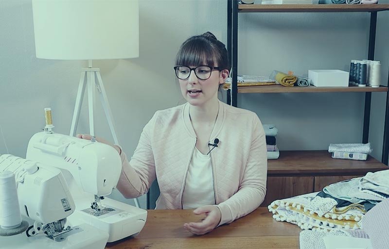 Frau an Nähmaschine mit Babysachen-Projekt, Anfängerkurs für Babystoffarbeiten