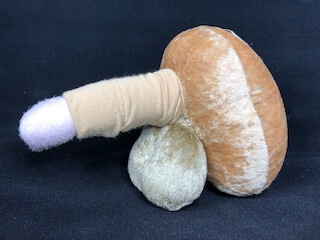 Stoffmodell Lingam mit cremefarbener Wicklung auf Leinenhintergrund
