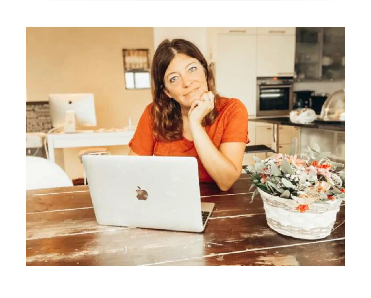 Nadja Horlacher arbeitet am Laptop in der Küche, wartet in nachdenklicher Pose