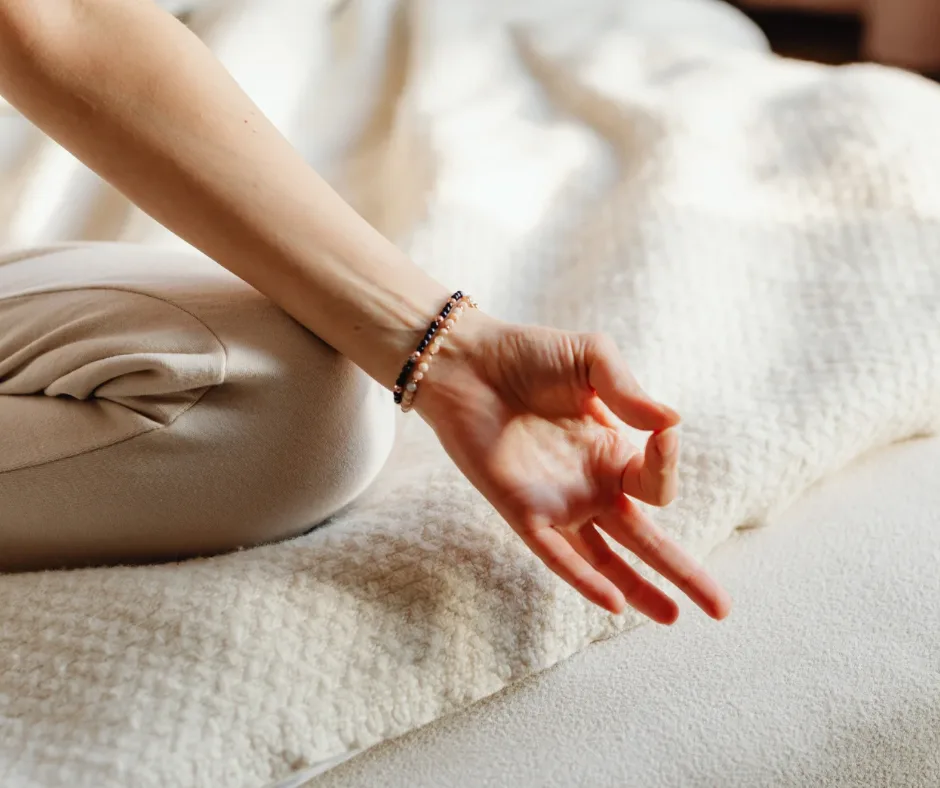 Healing Day – Selbstheilungstag mit Anleitung von Katja Demming 4 Frauenhand mit Armband über Meditationskissen in heller Zen-Umgebung