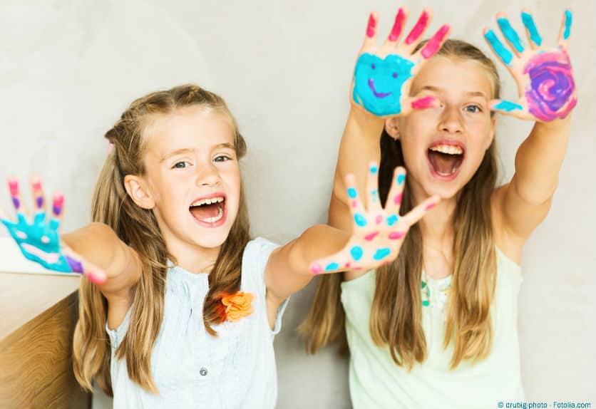 Heilungstrancen Vol. 02 – Hypnose-Audios zur Selbstheilung 4 Zwei Mädchen mit bemalten Händen zeigen bunte Handabdrücke mit Smiley-Gesichtern