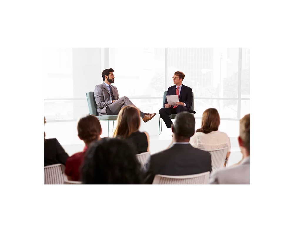 Geschäftsleute bei Seminar im modernen Büro mit Fensterfassade, zwei Männer im Gespräch