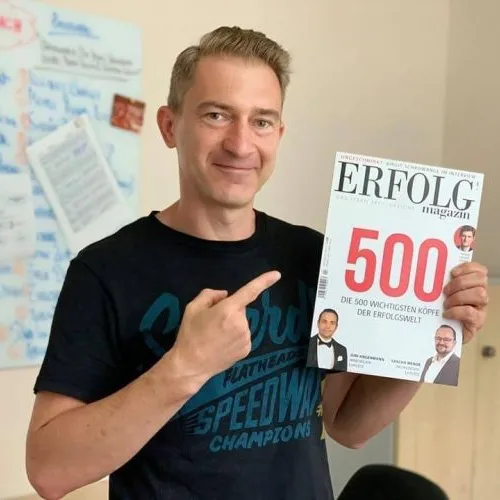 Eric Promm mit Erfolg Magazin, Mann zeigt auf Publikation