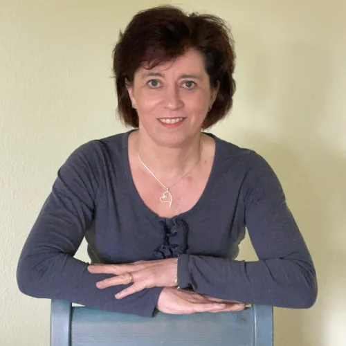 Ines Koban, Frau mit dunklem Haar lächelt zur Seite