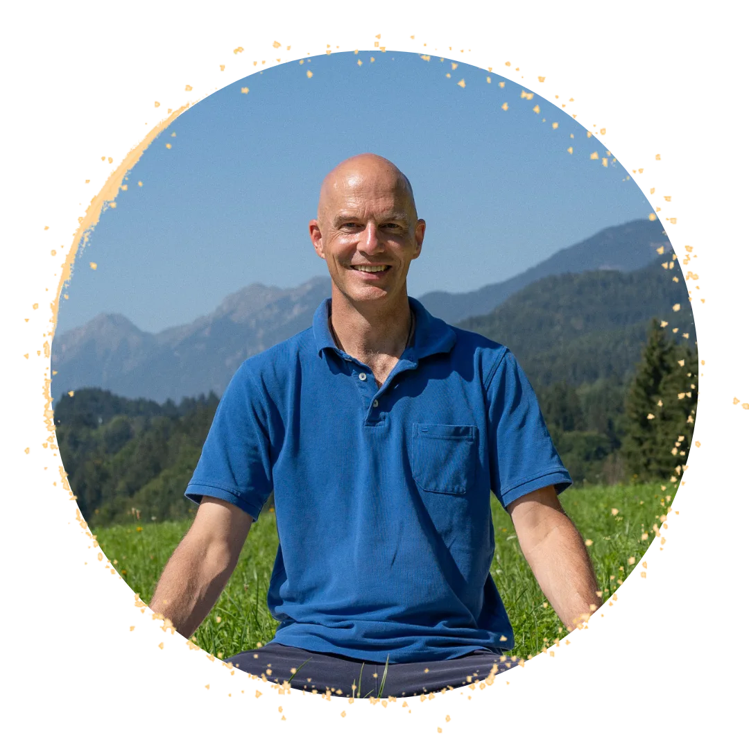 Portrait von Christian Opitz in blauem Poloshirt vor Berglandschaft mit grüner Wiese