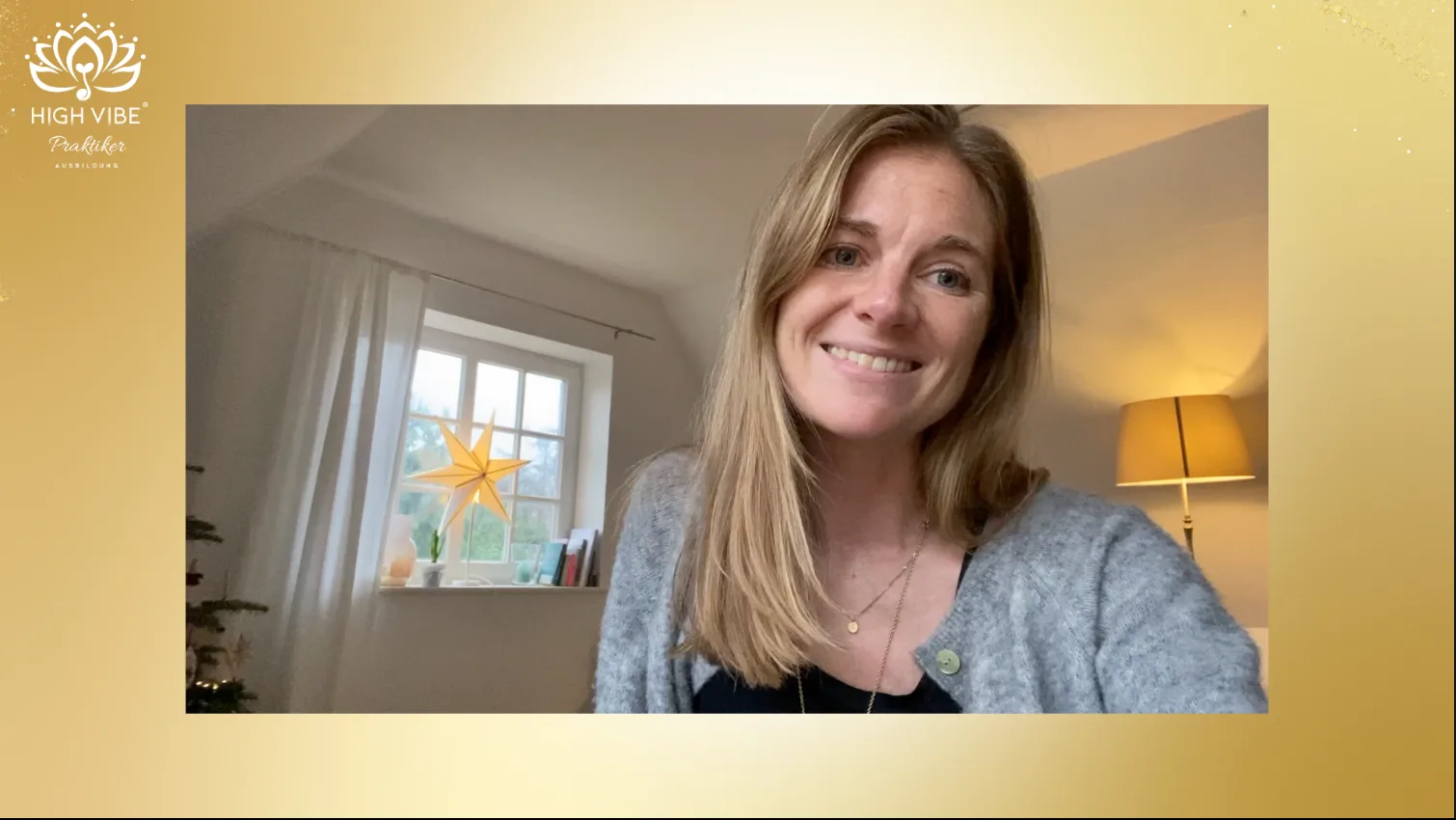 Videostandbild einer Frau lächelnd in heimischem Wohnzimmer mit Fenster