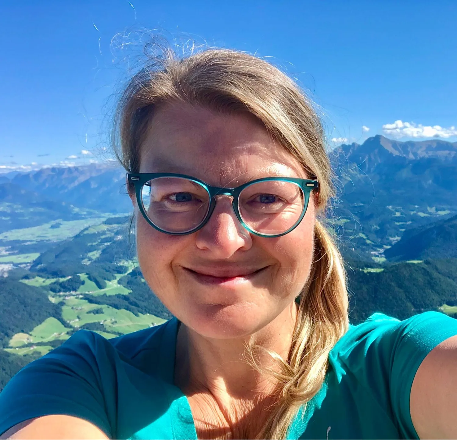 Selfie einer Frau mit Brille vor Berglandschaft mit Tälern