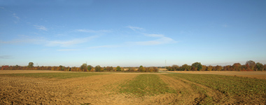 Panorama-Himmelhintergrund mit blauem Himmel über bestelltem Acker und flacher Landschaft