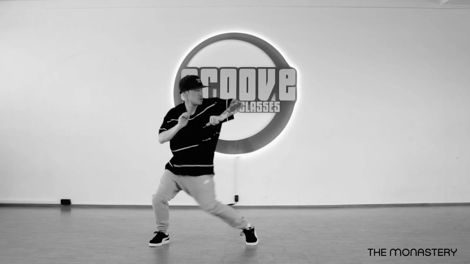 Hip Hop Basics – Hip-Hop-Tanzkurs per Video 5 Schwarz-Weiß-Standbild einer Tänzer beim Freestyle mit Groove Dance Academy Logo im Hintergrund