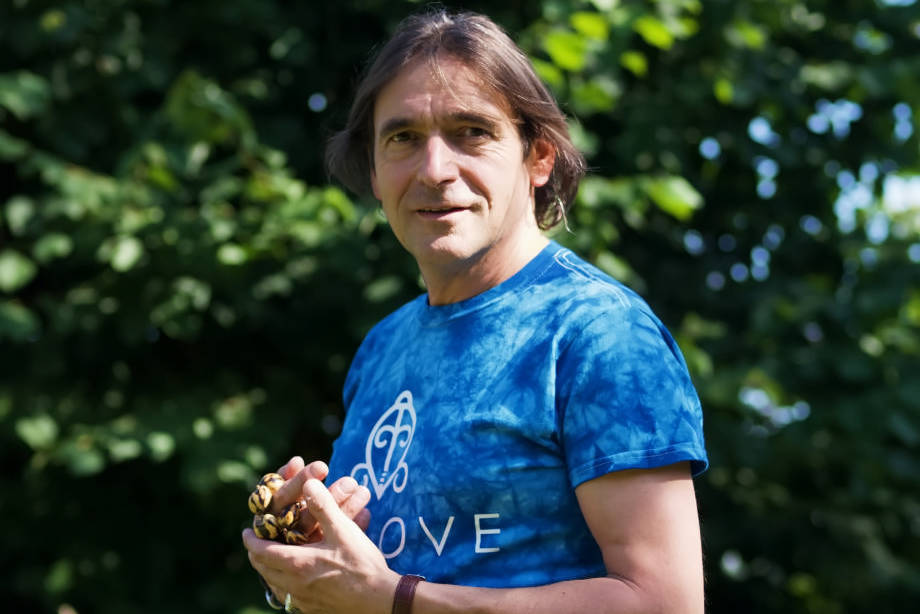 Porträt Ulrich Duprée in blauem T-Shirt mit spirituellem Symbol