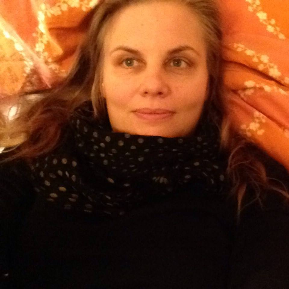 Porträt einer mittelalten Frau mit braunem Haar vor orangefarbenem Hintergrund