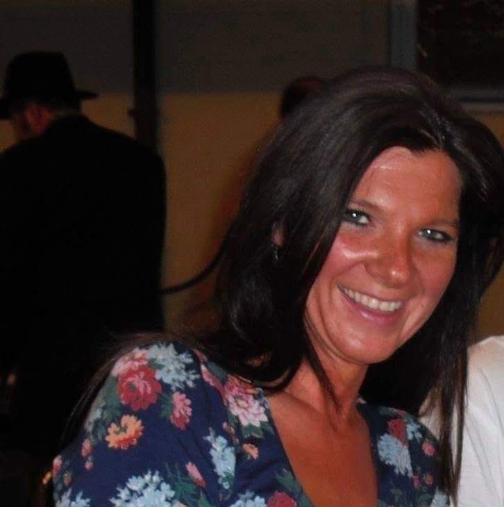 Frau mit schwarzen Haaren und Blumenshirt, lächelnd, Porträt