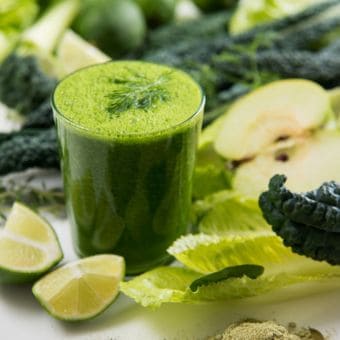 Grüner Detox-Smoothie in Glas mit Gemüse, Limette und Kräutern