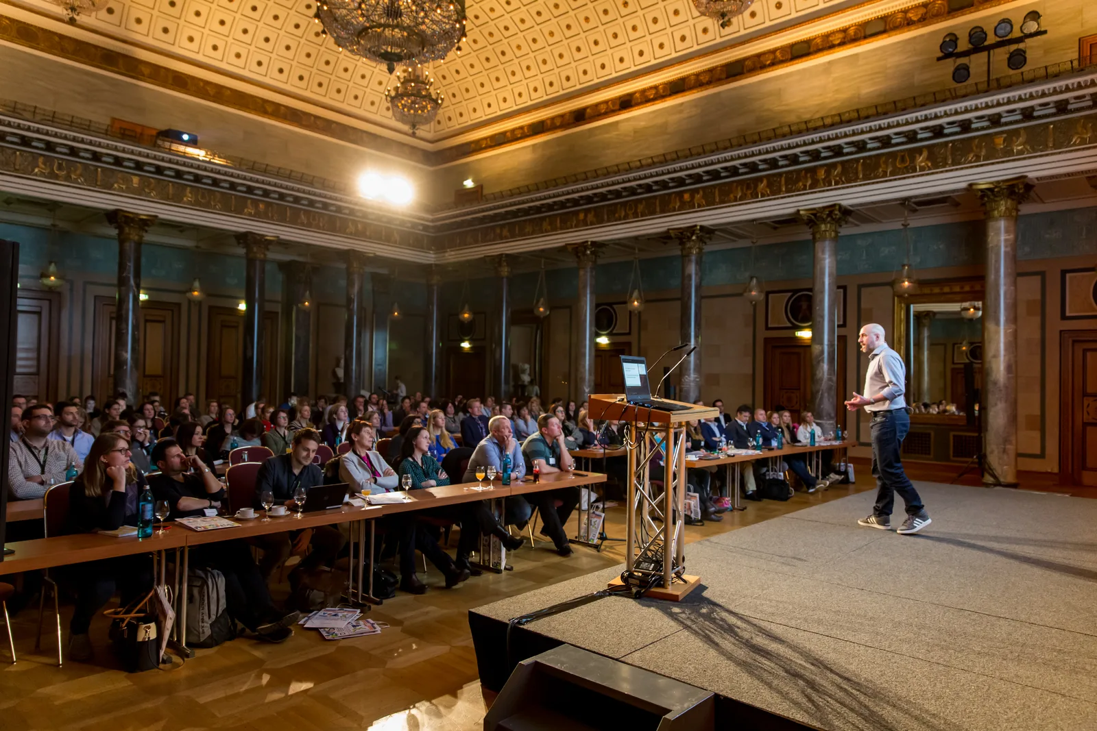 Vortrag in großem Saal mit Publikum und Redner am Podium