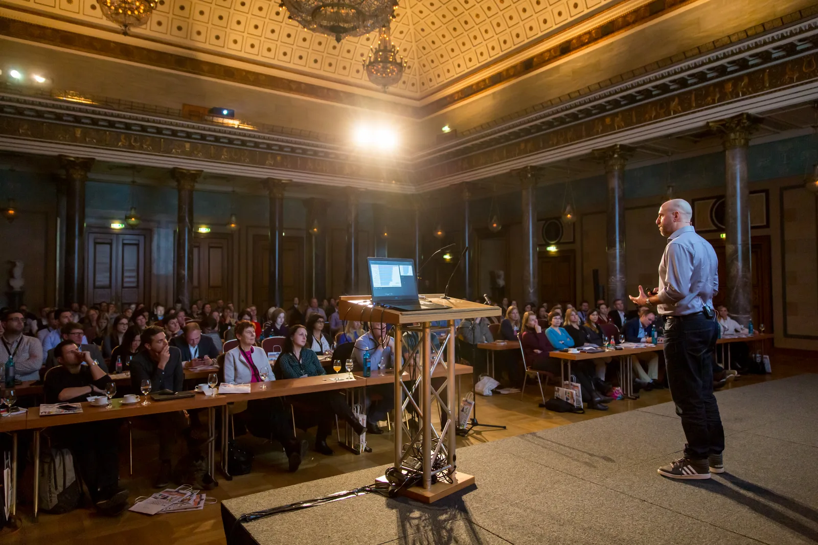 Großer Konferenzsaal mit Vortrag und Publikum an Tischen